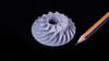 SLA miniature of compressor impeller next to a pencil for scale